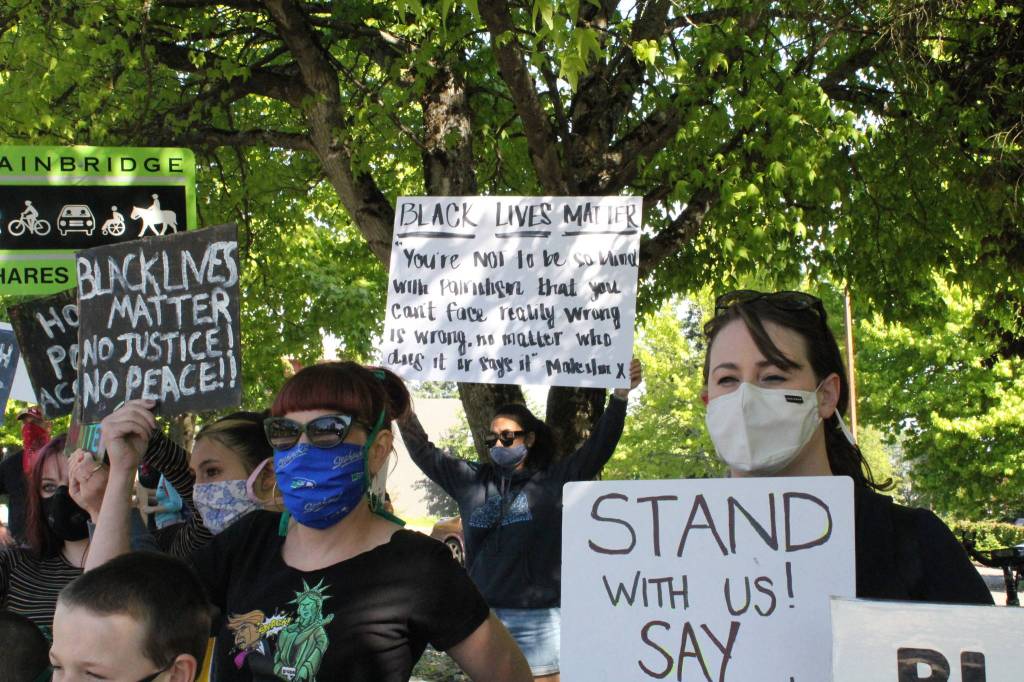 Protesters gather in Winslow as part of a demonstration organized by Kitsap ERACE Coalition. Photo by Nick Twietmeyer.