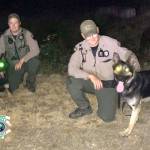 KCSO photo                                Bright-eyed K-9 Cooper and his handler, deputy A. Baker of Kitsap County Sheriffs Office (at right), pose alongside K-9 Blue and his handler during a nighttime training session last week.