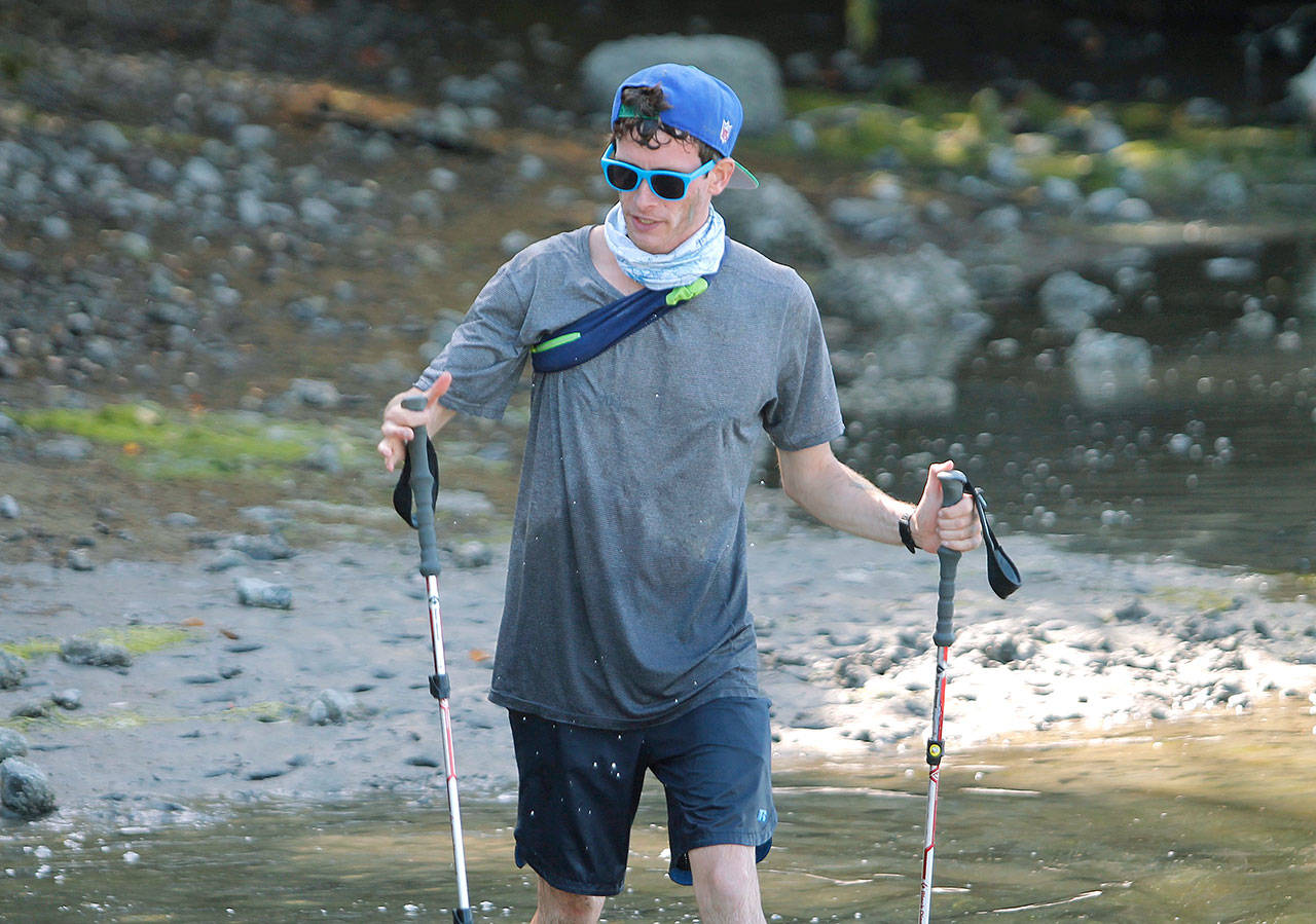 Island resident Greg Nance pulls up to the end of Point Monroe Drive near Fay Bainbridge Park during his endurance run around Bainbridge. (Mark Krulish/Kitsap News Group)
