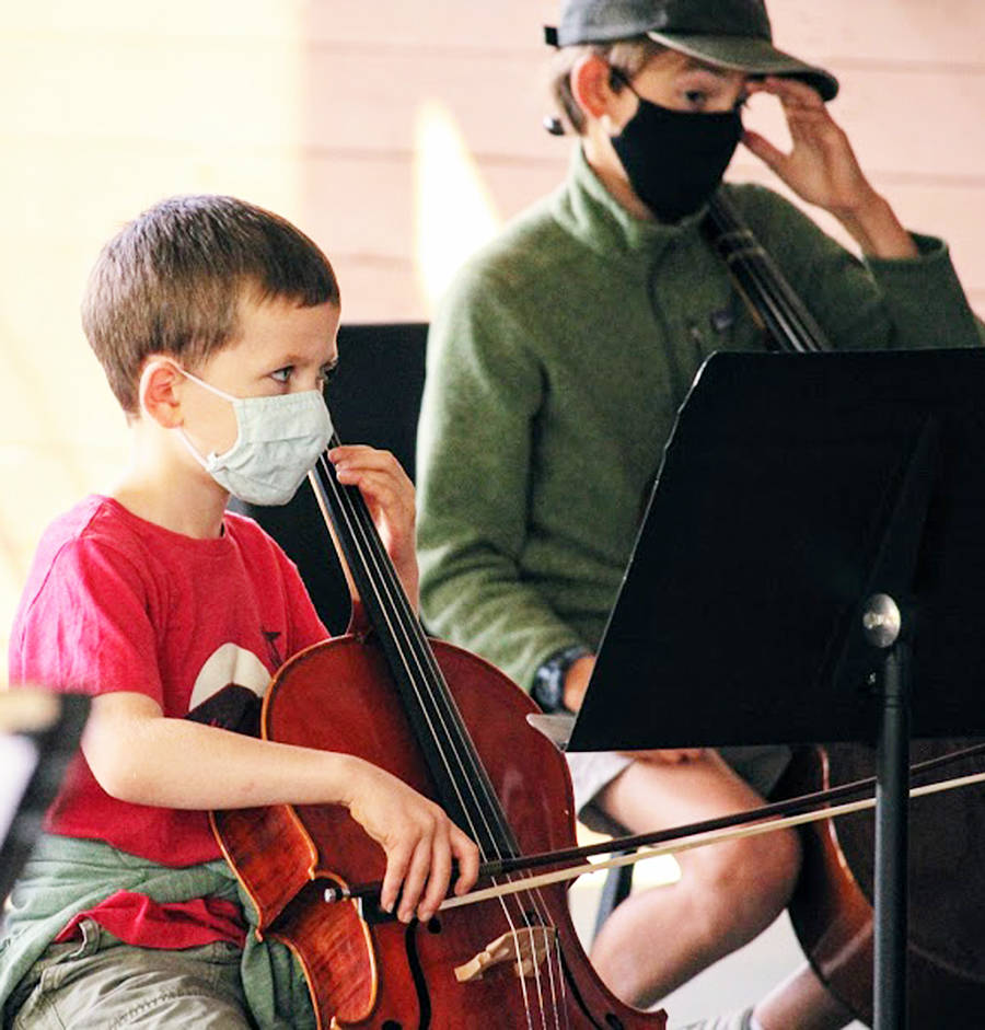 Musicians playing the cello and other string instruments wear masks as a safety precaution.