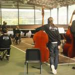 Orchestra members listen as conductor Tigran Arakelyan gives instructions.