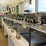 Harry Turnbull, extra help lead with the Kitsap County Elections Division, sends a batch of ballot envelopes through a processing reader prior to counting the ballots inside. (Bob Smith | Kitsap News Group 2018)