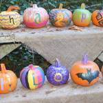 This group of pumpkins spells out "Happy Halloween" on a picnic table.