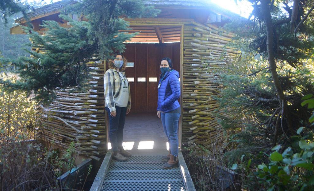 Breanna Caruso and Rachel Samuelson show a duck blind where students can hide from wild animals out on a marsh.
