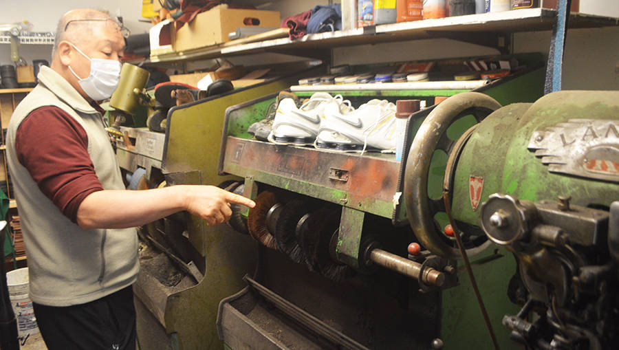 Chum Cho points to the different machines in his shop.