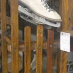A classic pair of skates hangs from another sled.