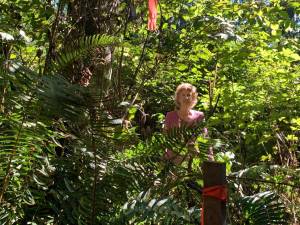 Neighbor Nina Meierding stands in the Ted Olson Nature Preserve. The post with the red ribbon marks the property line where development could occur. Courtesy photos