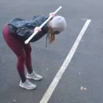 Bethanee Randles uses tubing and a parking space to show clients how to do this stretch.