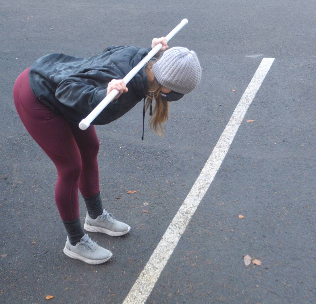 Bethanee Randles uses tubing and a parking space to show clients how to do this stretch.