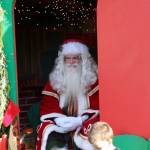 Santa sits serenely just inside his cottage, smiling as a small boy plucks up the courage to tell Santa what he wants for Christmas. KPark/NKH