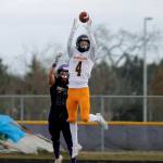 Bainbridge receiver Austin Coupland outleaps a Sequim defender for a reception. (Mark Krulish/Kitsap News Group)