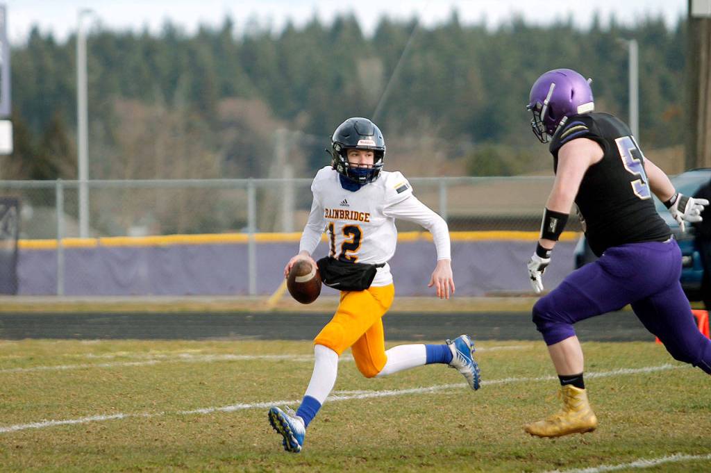 Bainbridge quarterback Gabriel Todd escapes the pocket to make a play against the Sequim pass rush. (Mark Krulish/Kitsap News Group)