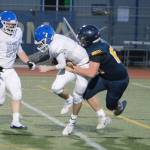 Bainbridge sophomore Sasha Herrmann brings down Olympic quarterback Dylan Boschee-Perry for a sack in his teams 34-28 victory. (Mark Krulish/Kitsap News Group)
