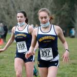 Bainbridge runners Lucy King (left) and Eden Michael (right) cross the finish line in the final regular season Olympic League meet at Battle Point Park against Bremerton. (Mark Krulish/Kitsap News Group)