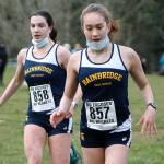 Bainbridge runners Lucy King (left) and Eden Michael (right) cross the finish line in the final regular season Olympic League meet at Battle Point Park against Bremerton. (Mark Krulish/Kitsap News Group)