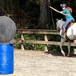 Melissa Davis takes aim with her bow at a target at the Saddle Club.