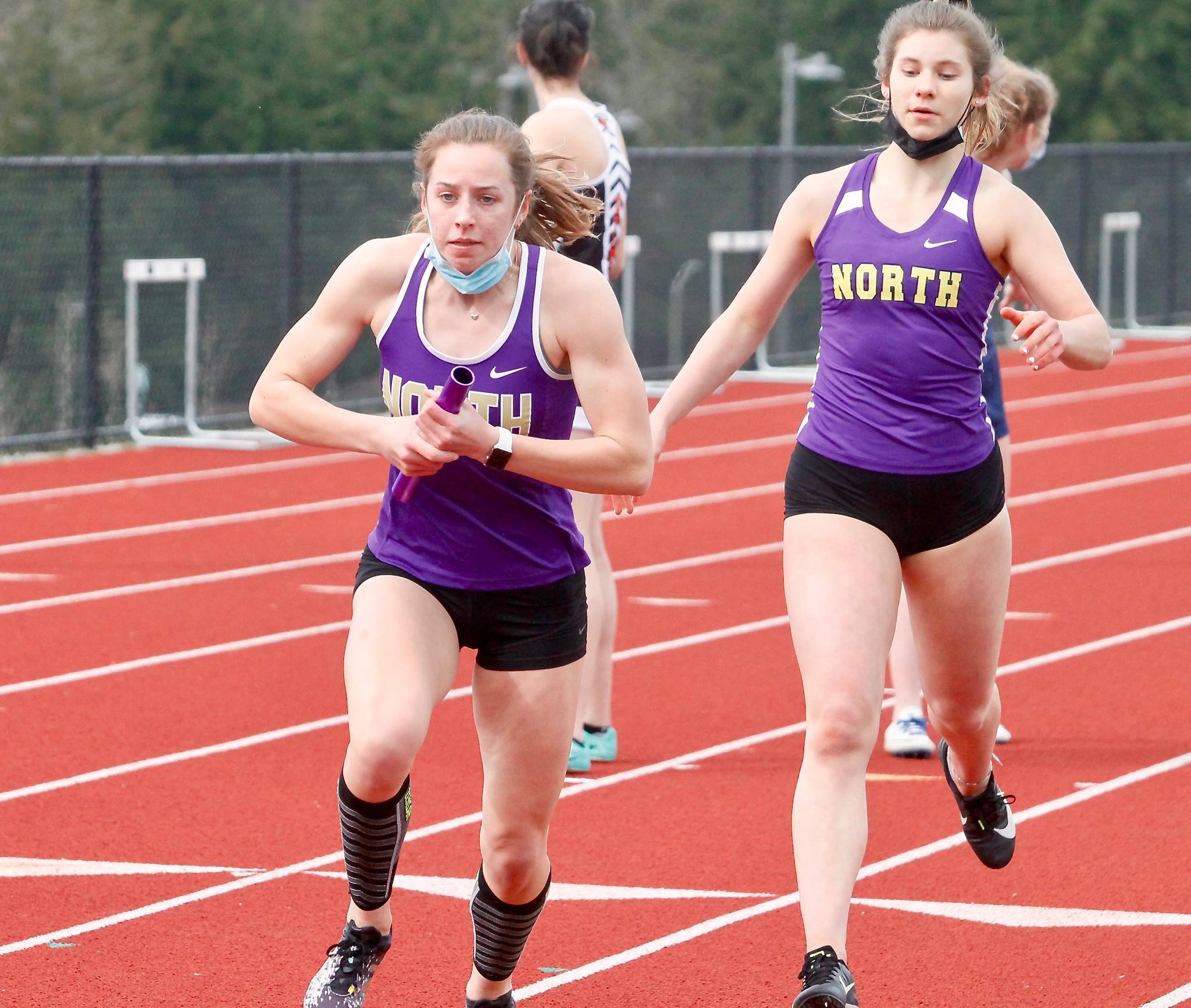 North Kitsaps Alyssa Cullen (front) takes the baton from Genesi Funston in the 4x200 relay. (Mark Krulish/Kitsap News Group)