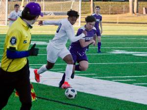 Bainbridge forward Damoni Mckenna-Greenawalt looks to break away down the sideline as North Kitsaps Dylan Brindle gives chase. (Mark Krulish/Kitsap News Group)
