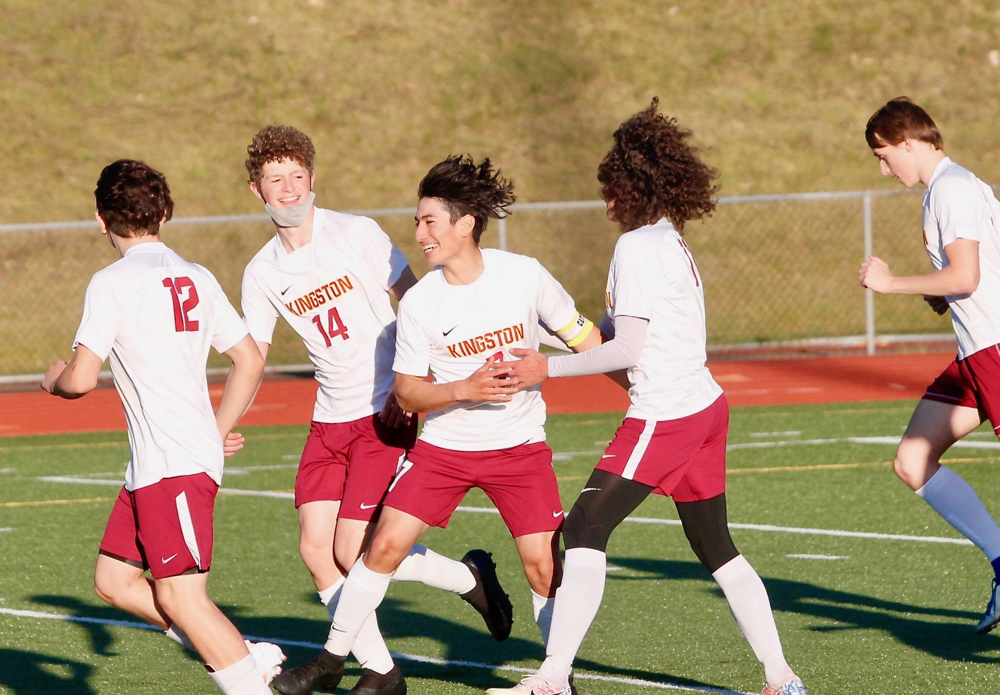 Kingston senior Kevin Aragon is surrounded by teammates after scoring his teams opening goal against Olympic on Thursday. (Mark Krulish/Kitsap News Group)