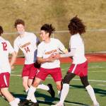 Kingston senior Kevin Aragon is surrounded by teammates after scoring his teams opening goal against Olympic on Thursday. (Mark Krulish/Kitsap News Group)