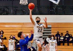 Everett Moore gets up and over the Olympic defense for a shot attempt. Moore hit four 3-pointers in Bainbridges win over the Trojans. (Mark Krulish/Kitsap News Group)