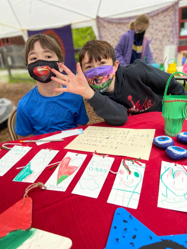 Chris Butterly, 8, and Billy Baxter, 8, sell Omani flag bookmarks and paperweights.