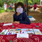 Kavi Danielson, 9, displays trading cards featuring the sea turtles, mosques, palm trees and camels of Oman.