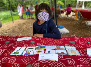 Kavi Danielson, 9, displays trading cards featuring the sea turtles, mosques, palm trees and camels of Oman.