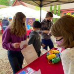 Fifth graders Adelaide Scott, 11, Cruz Garcia, 10, and Dylan MacCulloch, 11, admire the paper lanterns and handmade trading cards offered by Liviana Lannon Eatinger, 8.