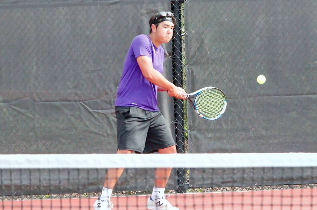 North Kitsaps Drake Jones returns a volley from the baseline during the Olympic League doubles finals match. (Mark Krulish/Kitsap News Group)