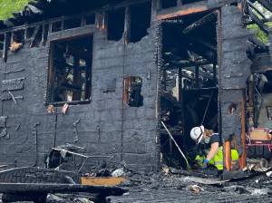 Deputy fire marshal Kristi Wlodarchak photographs the area of origin of the fire that displaced five and severely damaged a home.