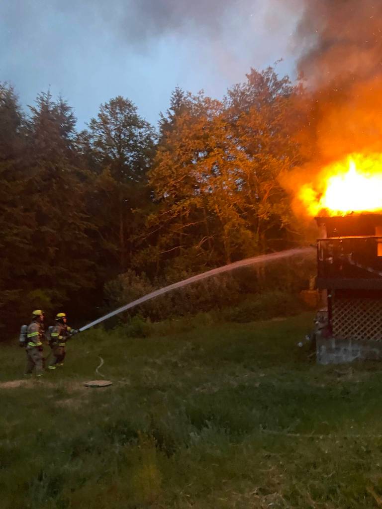 Firefighters Tony Reichmuth, left, and Corey Brown work to control the flames at the Kingston home.