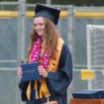 A happy graduate holds up her diploma. Tyler Shuey/Bainbridge Island Review