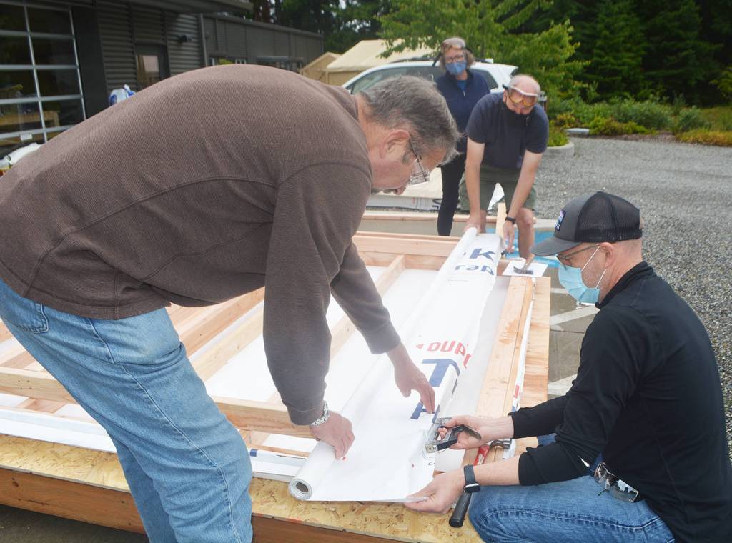 Volunteers work on one of the sides of the house.