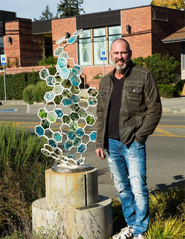 White, who does the metal sculpting, stands by Fossil II. Courtesy photo