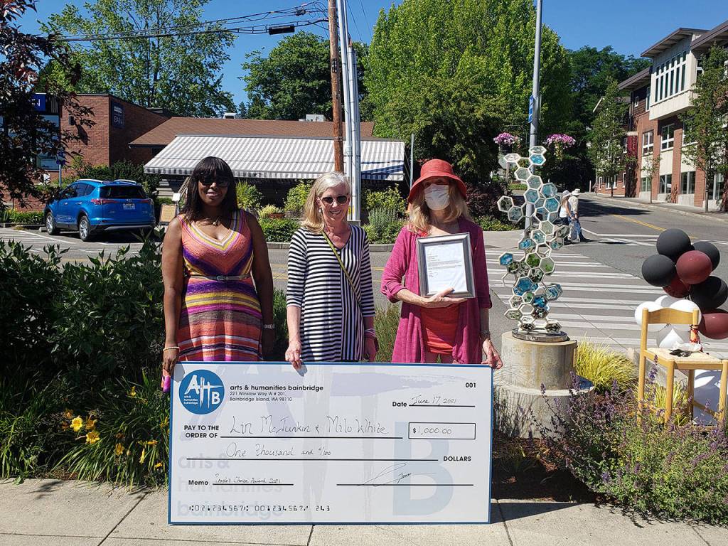 Lin McJunkin (right) accepts her $1,000 check and letter from the city of Bainbridge Island from members of Arts & Humanities Bainbridge. Tyler Shuey/Bainbridge Island Review