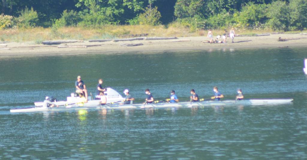A rowing team was out on the waters of Eagle Harbor Monday with some early beachgoers in the background.
