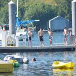 Young adults go swimming off a dock in Eagle Harbor Monday morning.