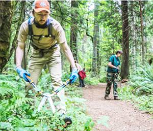 Will Gleason uses clippers to cut back vegetation near a trail. Courtesy Photos