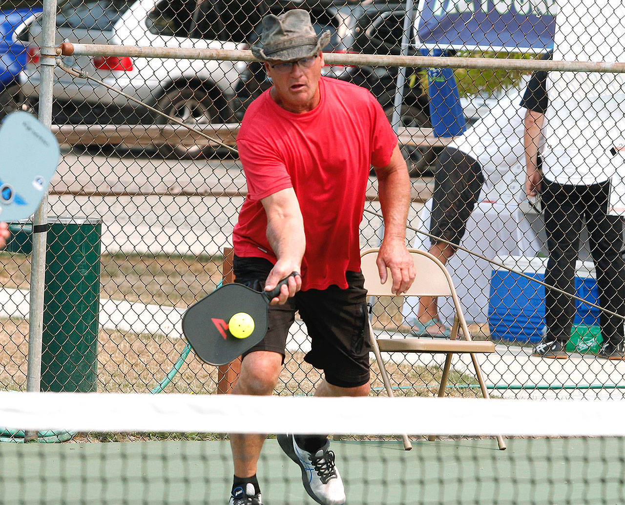 Don Sickle of Bainbridge Island makes a play at the net during a medal match in the Mixed Doubles tournament. Sickle and his partner, Kim Hemingway, won silver in the 3.0, 50+ group. (Mark Krulish/Kitsap News Group)