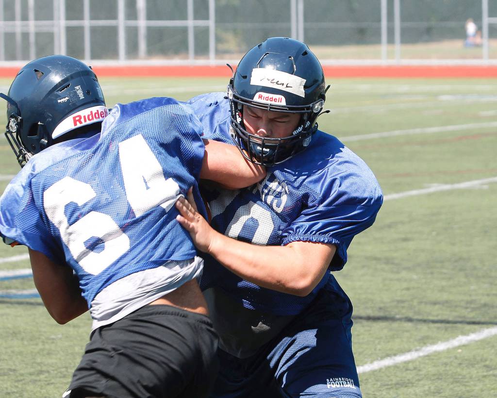 Bainbridge senior Connor Sweeny wraps up a teammate during practice. (Mark Krulish/Kitsap News Group)