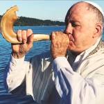 Rabbi Dario Feiguin blows into a shofar, an ancient musical horn typically made of a rams horn.
