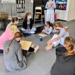 Students gather to write challenges on their boards before learning how to break them - a popular activity at the workshops. (Contributed photo)