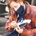 Band mom Kristen Gagnon fastens a loose button on one of the uniforms.