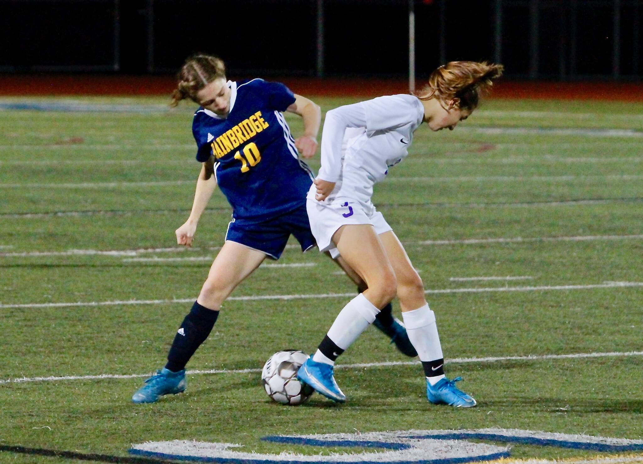 Bainbridge senior Maddy Brown looks to pry the ball loose from a Sequim player during her teams 1-0 win Thursday night. Mark Krulish/Bainbridge Island Review photos