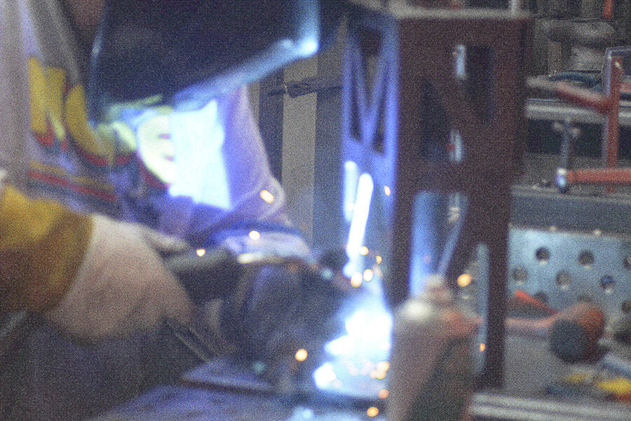 A welder works in the metal shop.