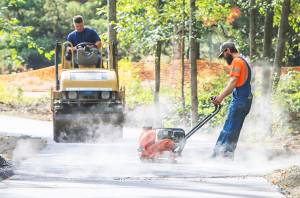 Workers put the finishing touches on asphalt on the new Sakai Trail portion of the Sound to Olympics trail. Courtesy Photo