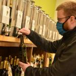 Jeremy Wake, co-owner of Lively Olive Tasting Bar, fills a bottle with olive oil.