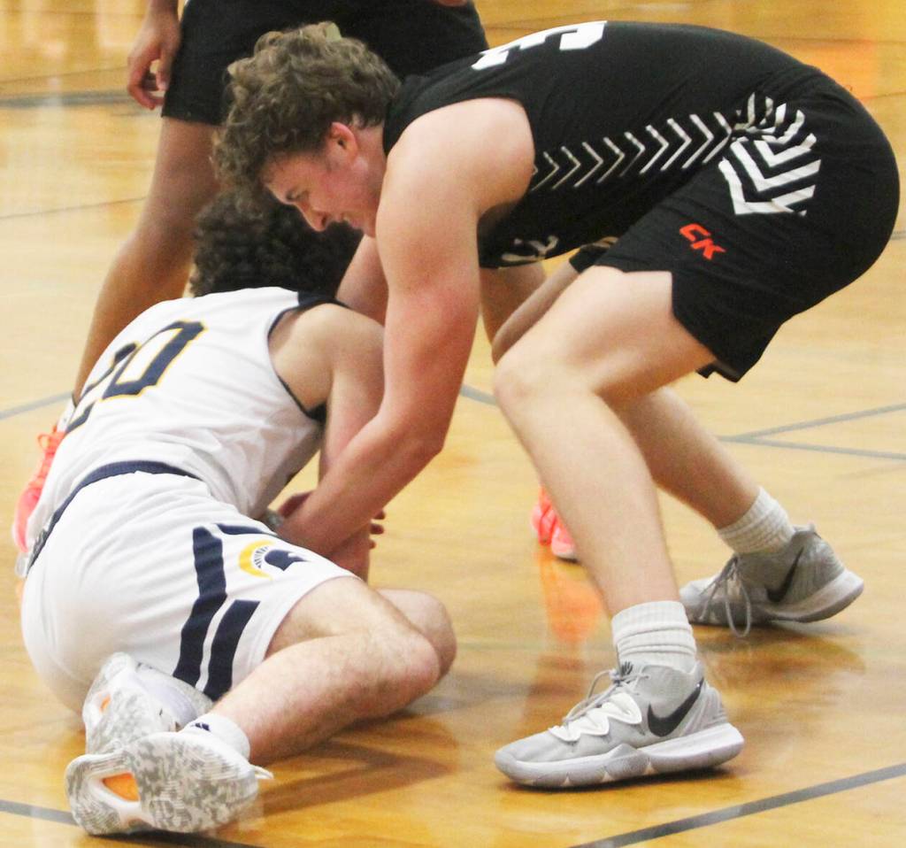A hustling Henry Cartsen (20) dives on the floor to get a loose ball in a game against CK.