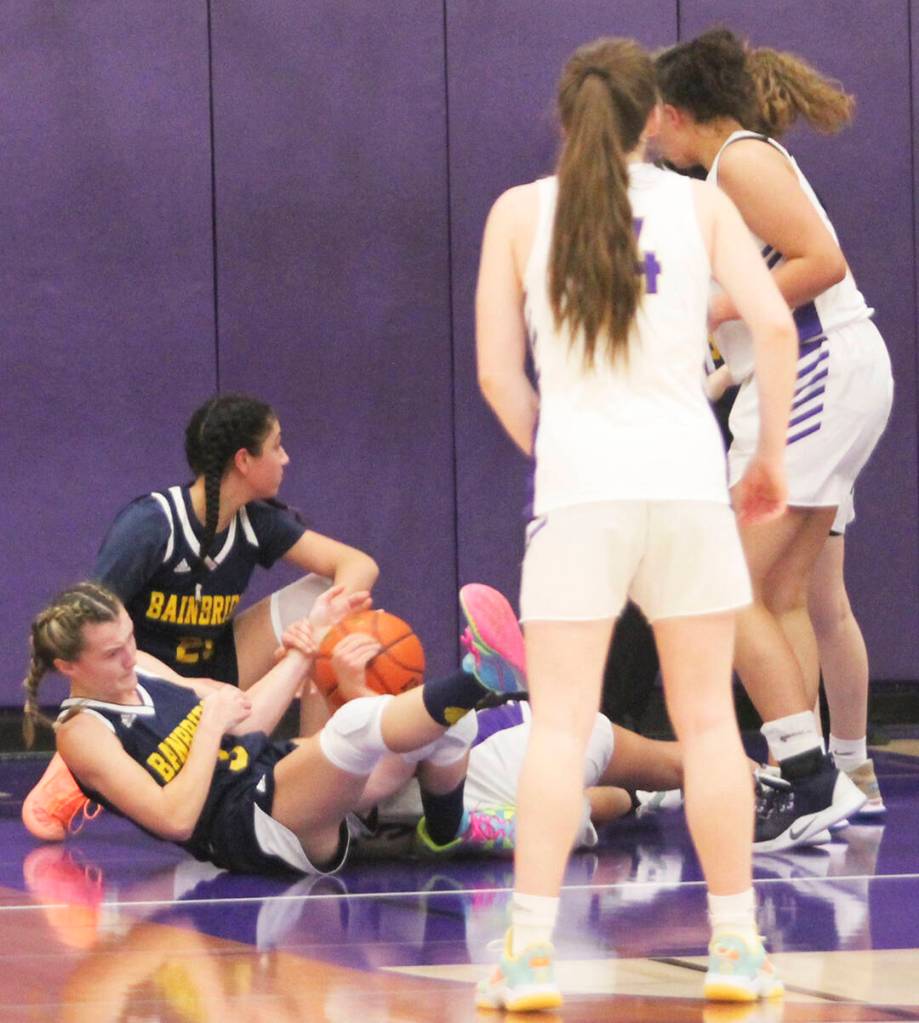 Maia Greiwe and Ghadir Ramadan of Bainbridge hit the floor going after a loose ball against NK.